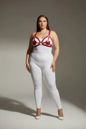 Red faux leather strappy harness with heart details and silver rings worn by a plus-size model