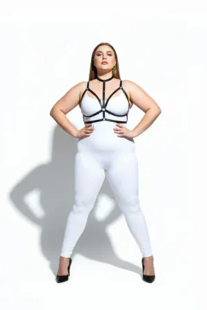 Black faux leather strappy body harness with central O-ring detail, worn by a plus-size model.