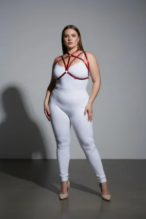 Red faux leather strappy chest harness with O-ring detail worn by a plus-size model