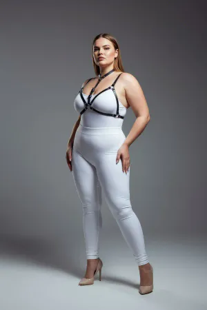 Black faux leather strappy body harness worn by a plus-size model, showing adjustable straps and O-ring detail.