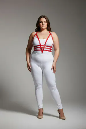 Red faux leather body harness with adjustable straps worn by a plus size model