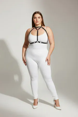 Black faux leather strappy body harness with silver O-rings and adjustable straps worn by a plus-size model.