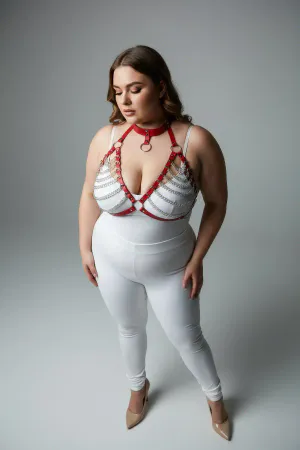 Red faux leather body harness with cascading silver chains and O-ring detail, worn by a plus-size model.
