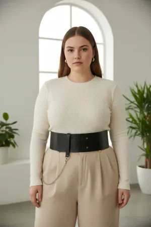 Black Faux Leather Wide Waist Belt with Silver Chain Detail, worn by a woman with a white top and light trousers
