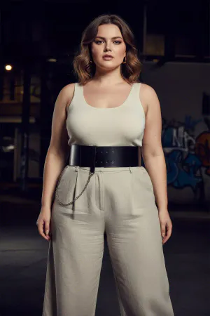 Black Faux Leather Wide Waist Belt with Silver Chain Detail, worn by a woman with a white top and light trousers